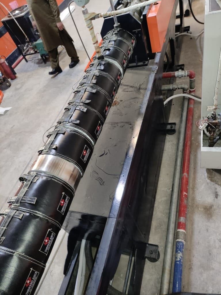 Partially insulated extrusion barrel next to open heater zones